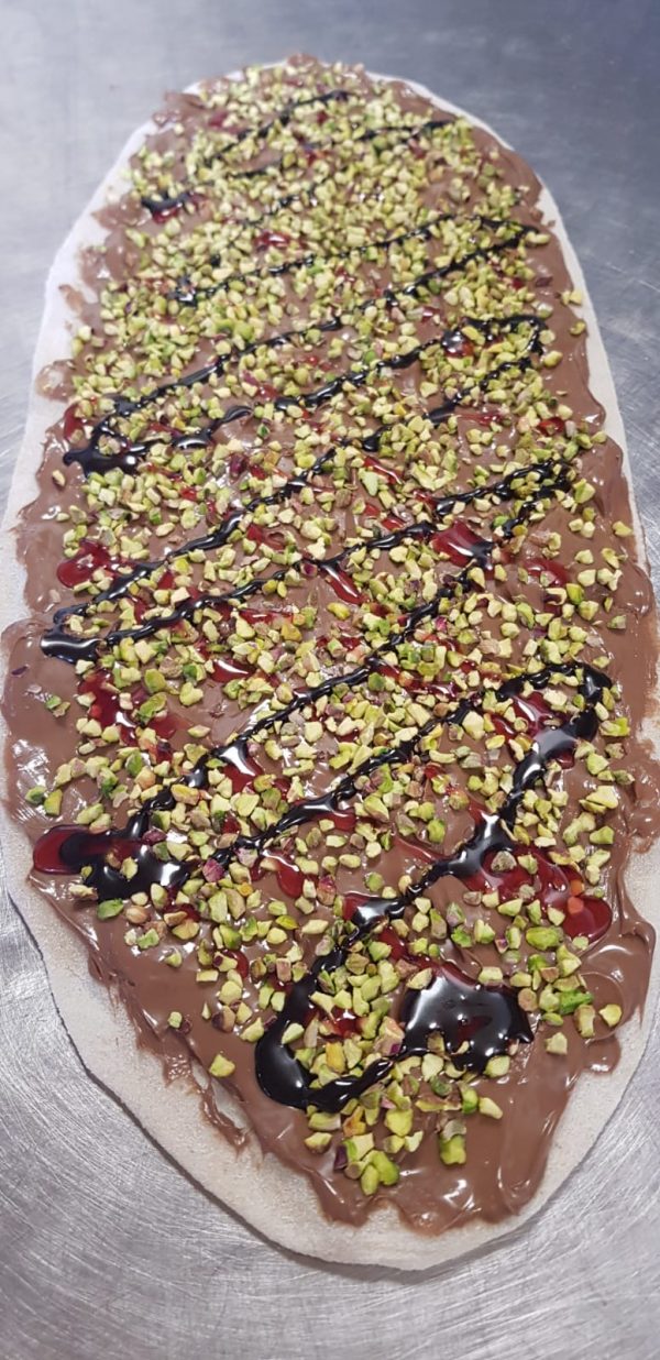 Pizza cioccolata alla nocciola, granella pistacchi.